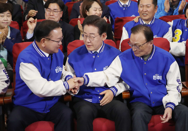 민주당 이재명 대표, 이해찬·김부겸 상임공동선거대책위원장이 10일 오후 서울 영등포구 여의도 국회 의원회관에 마련된 제22대 국회의원선거(총선) 민주당 개표 상황실에서 방송사 출구조사 결과를 지켜본 뒤  악수를 나누고 있다. 연합뉴스